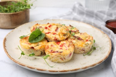 Photo of Freshly baked bacon and egg muffins with cheese on table, closeup