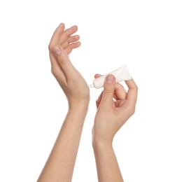 Photo of Woman applying cream from tube on hand against white background, closeup