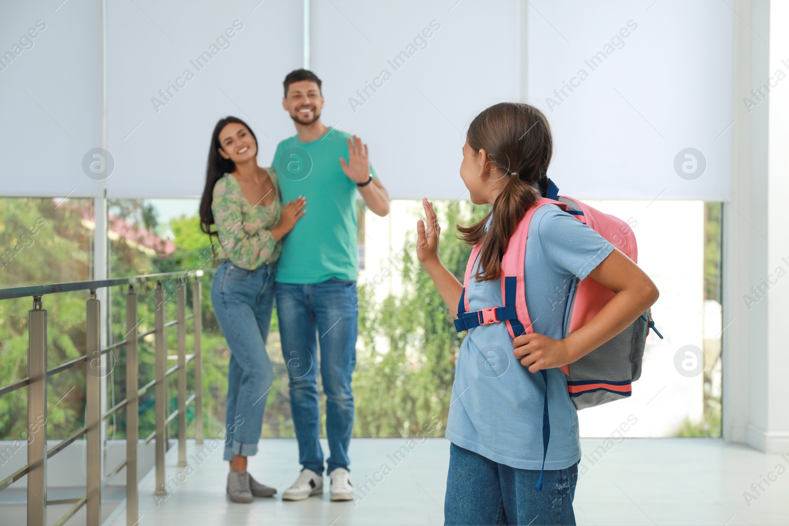 Photo of Parents waving goodbye to their daughter in school