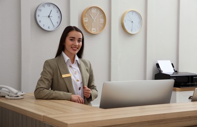 Portrait of beautiful receptionist at counter in hotel