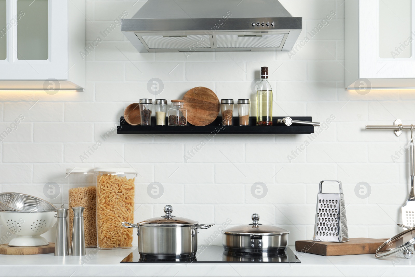 Photo of Countertop with different cooking utensils and stove in kitchen