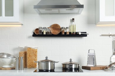 Photo of Countertop with different cooking utensils and stove in kitchen