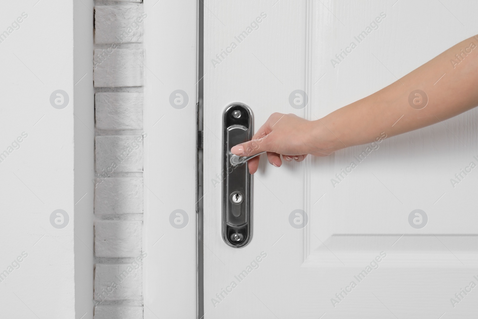 Photo of Woman opening white wooden door, closeup view