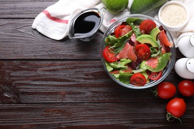 Tasty soy sauce, bowl with salad and ingredients on wooden table, flat lay. Space for text