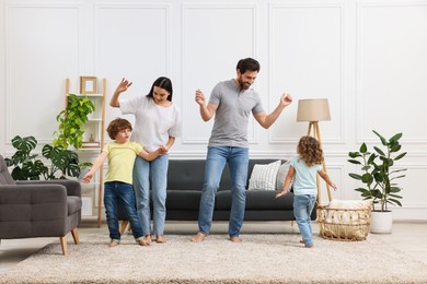 Photo of Happy family dancing and having fun in living room