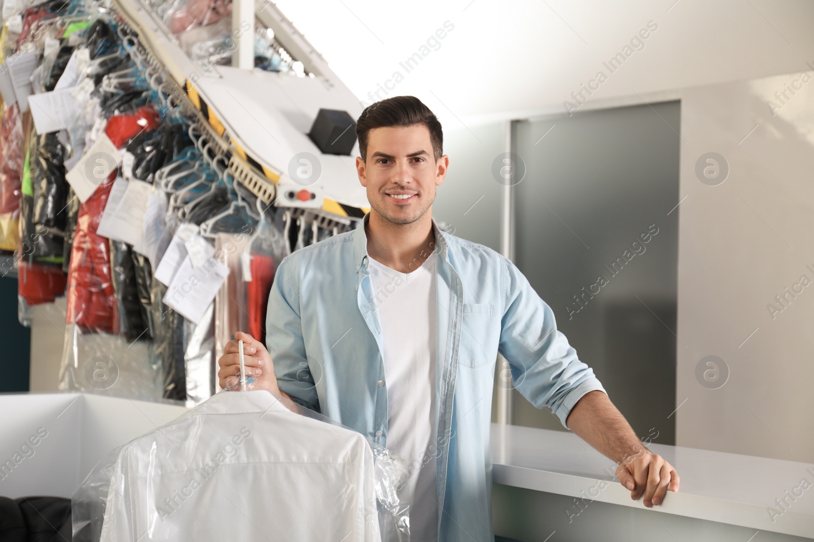 Photo of Happy client with shirt at modern dry-cleaner's