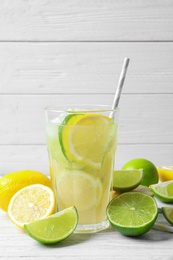 Glass of natural lemonade with citrus fruits on table