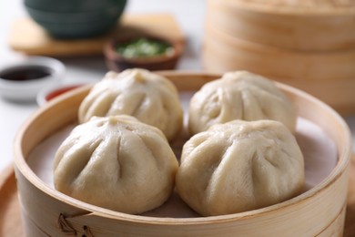 Photo of Delicious bao buns (baozi) on light table, closeup