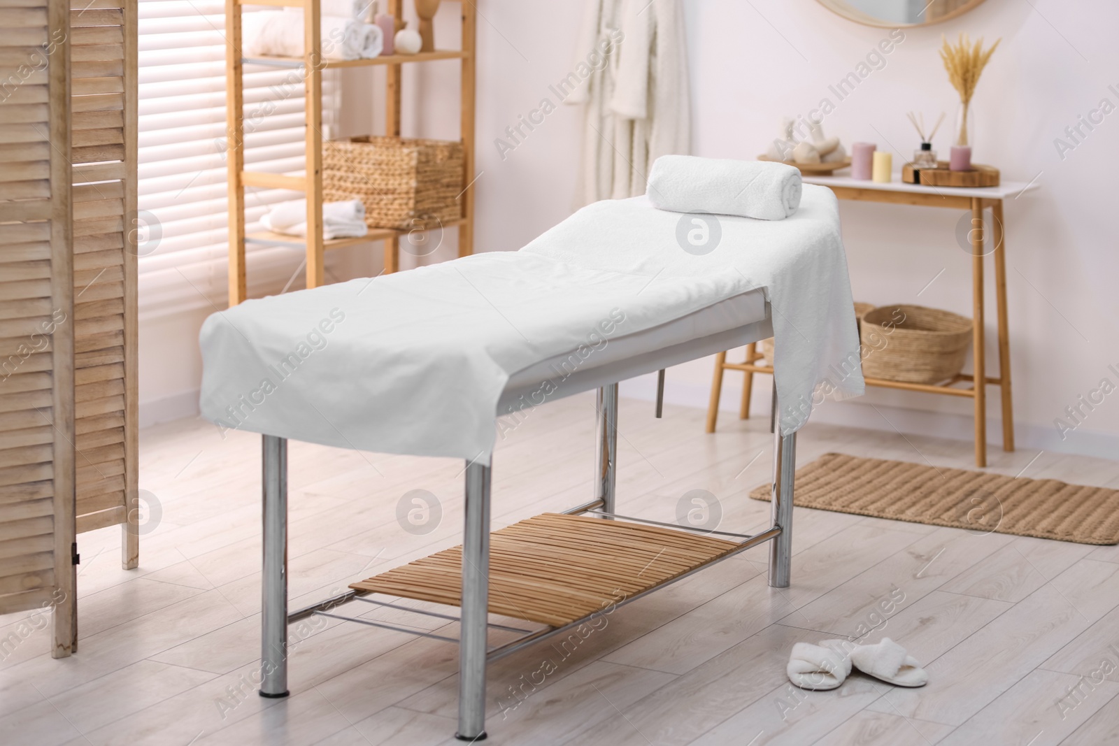 Photo of Comfortable massage table with clean towels in spa center