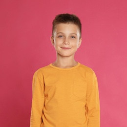 Photo of Cute little boy posing on pink background