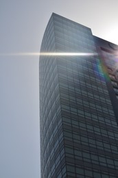 Photo of Exterior of beautiful modern skyscraper against blue sky, low angle view