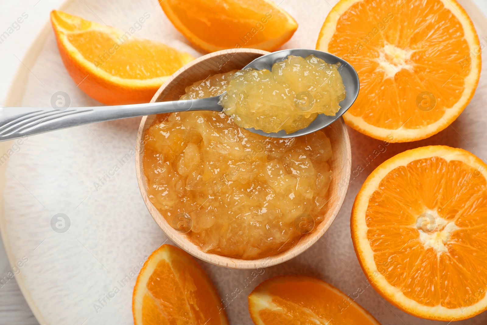 Photo of Bowl of delicious orange jam and fresh fruits on white table, top view