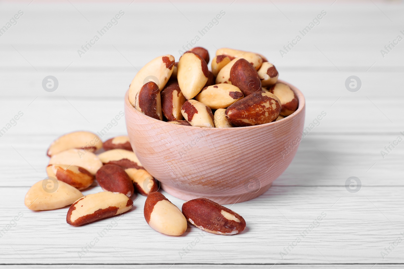 Photo of Delicious Brazil nuts on white wooden table