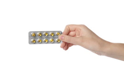 Woman holding pills in blister pack on white background, closeup