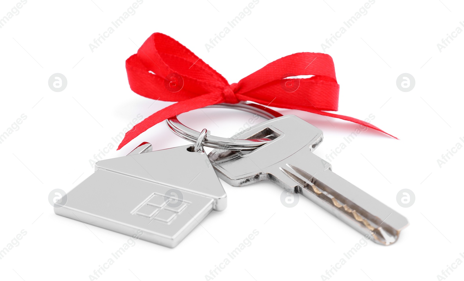 Photo of Key with keychain in shape of house and red bow isolated on white