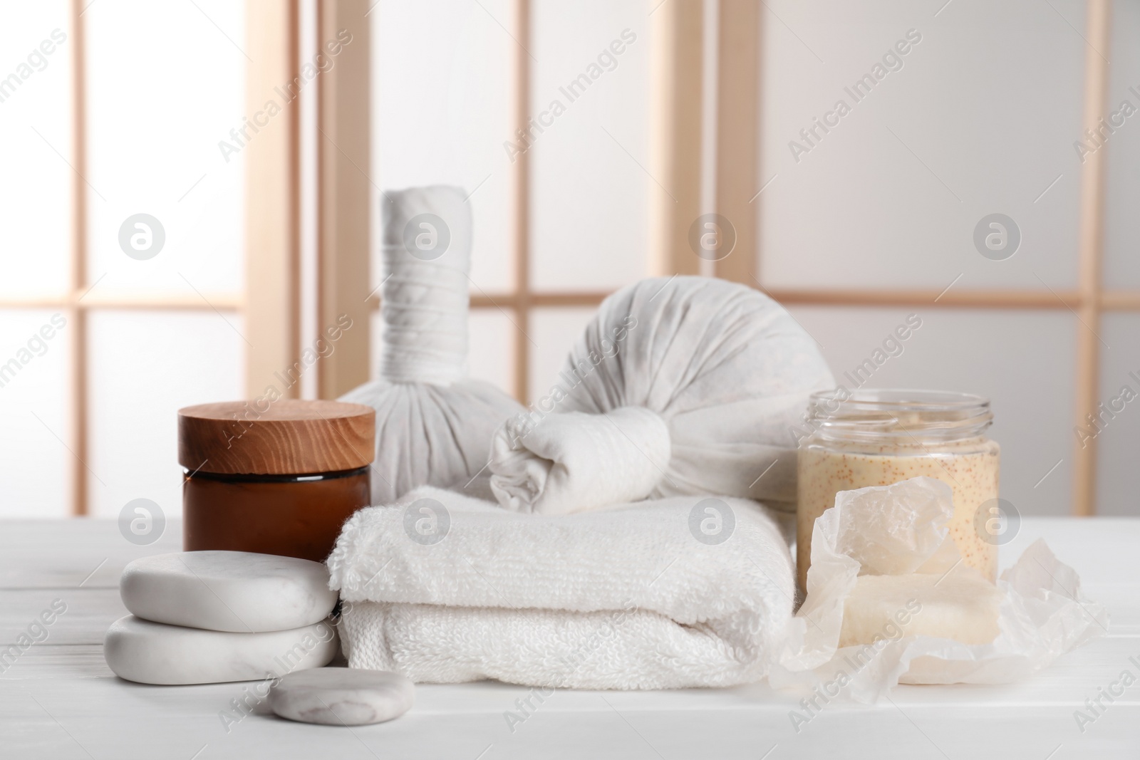 Photo of Spa composition with care products on white wooden table in room