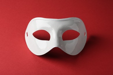 Photo of White plastic theatre mask on red background