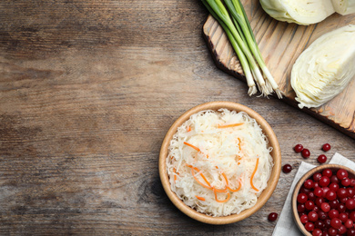 Photo of Flat lay composition with fermented cabbage on wooden table, space for text