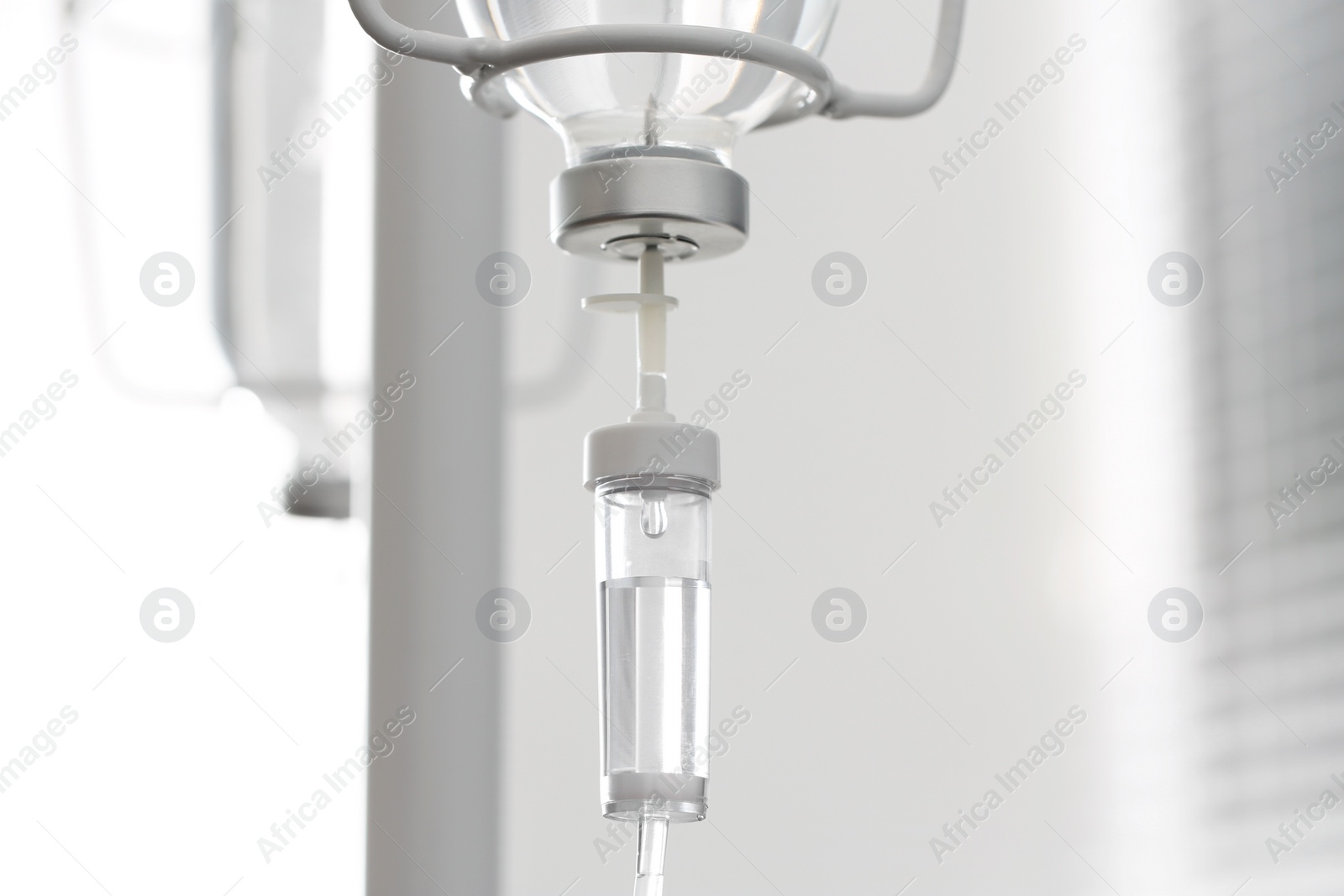 Photo of IV drip chamber against blurred light background