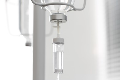 Photo of IV drip chamber against blurred light background