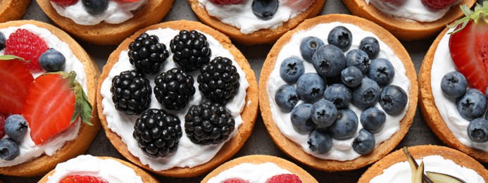 Image of Delicious tartlets with fresh berries, top view. Banner design