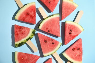 Photo of Slices of ripe watermelon on light blue background, flat lay