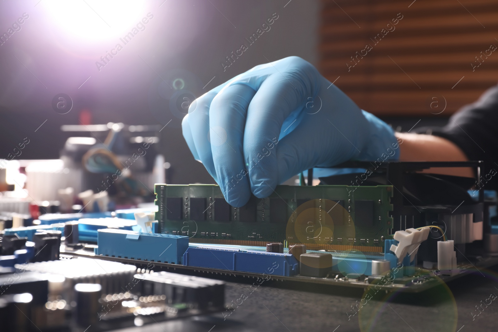 Photo of Technician repairing computer motherboard at table, closeup. Electronic device