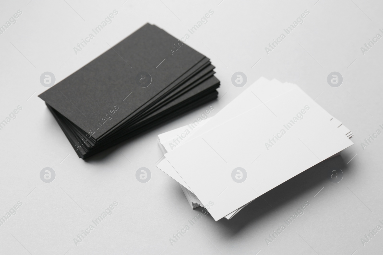 Photo of Blank black and white business cards on light background. Mockup for design