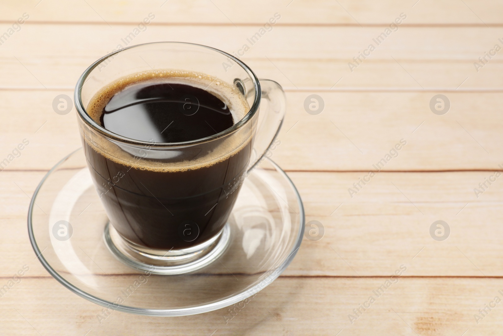 Photo of Cup of aromatic coffee on light wooden table, closeup. Space for text