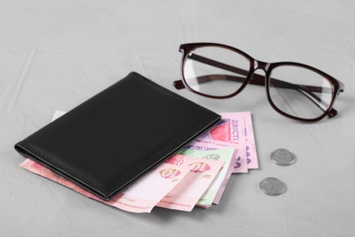 Pension certificate with Ukrainian money and glasses on grey stone background