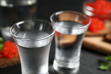 Photo of Cold Russian vodka on black table, closeup view