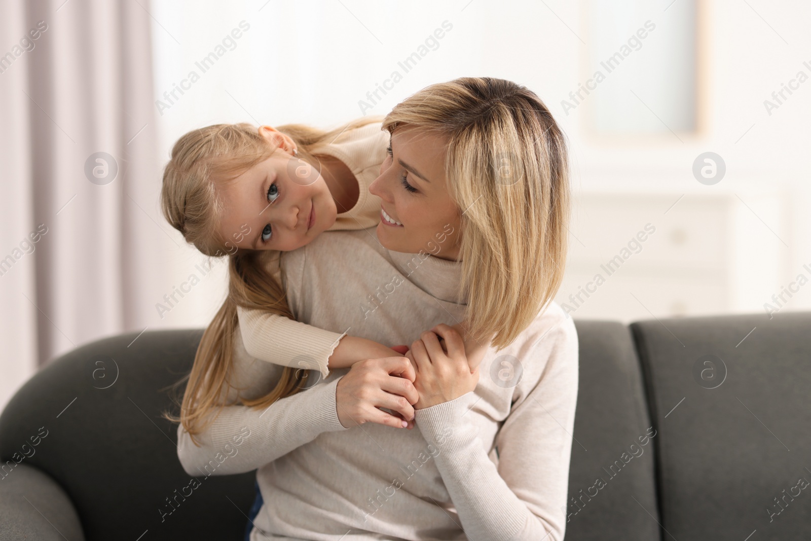 Photo of Happy mother and daughter on sofa at home