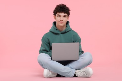 Photo of Portrait of student with laptop on pink background