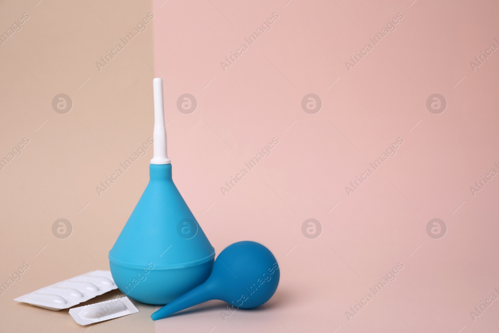 Photo of Enemas and suppositories on color background, space for text. Medical treatment