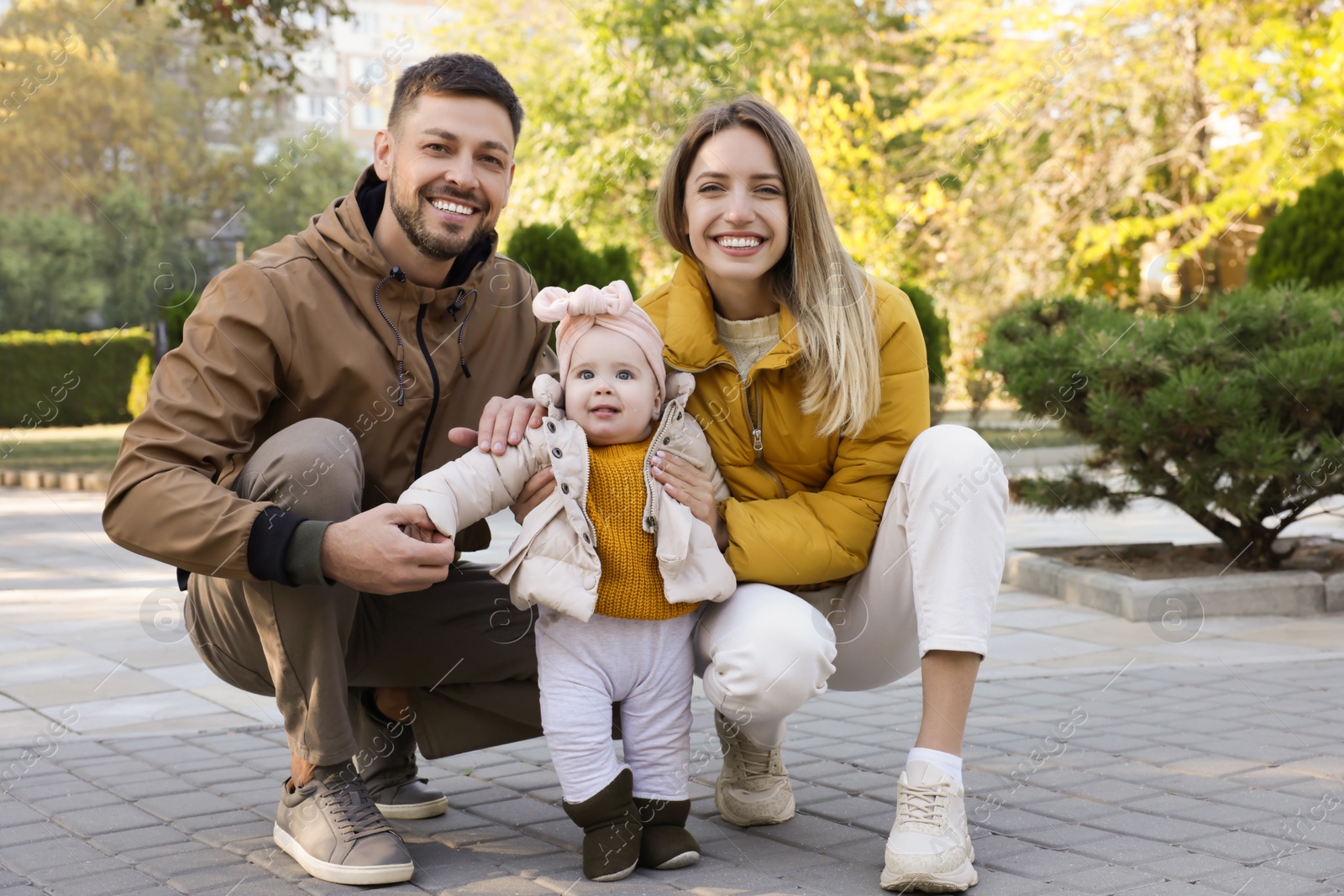 Photo of Happy parents with their baby in park on sunny day