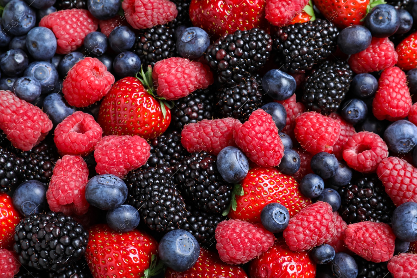 Photo of Mix of different ripe tasty berries as background, top view