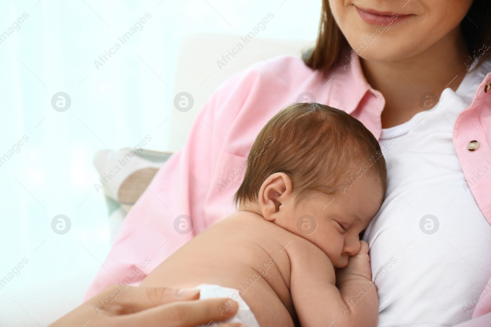 Photo of Young mother with her little baby on light background