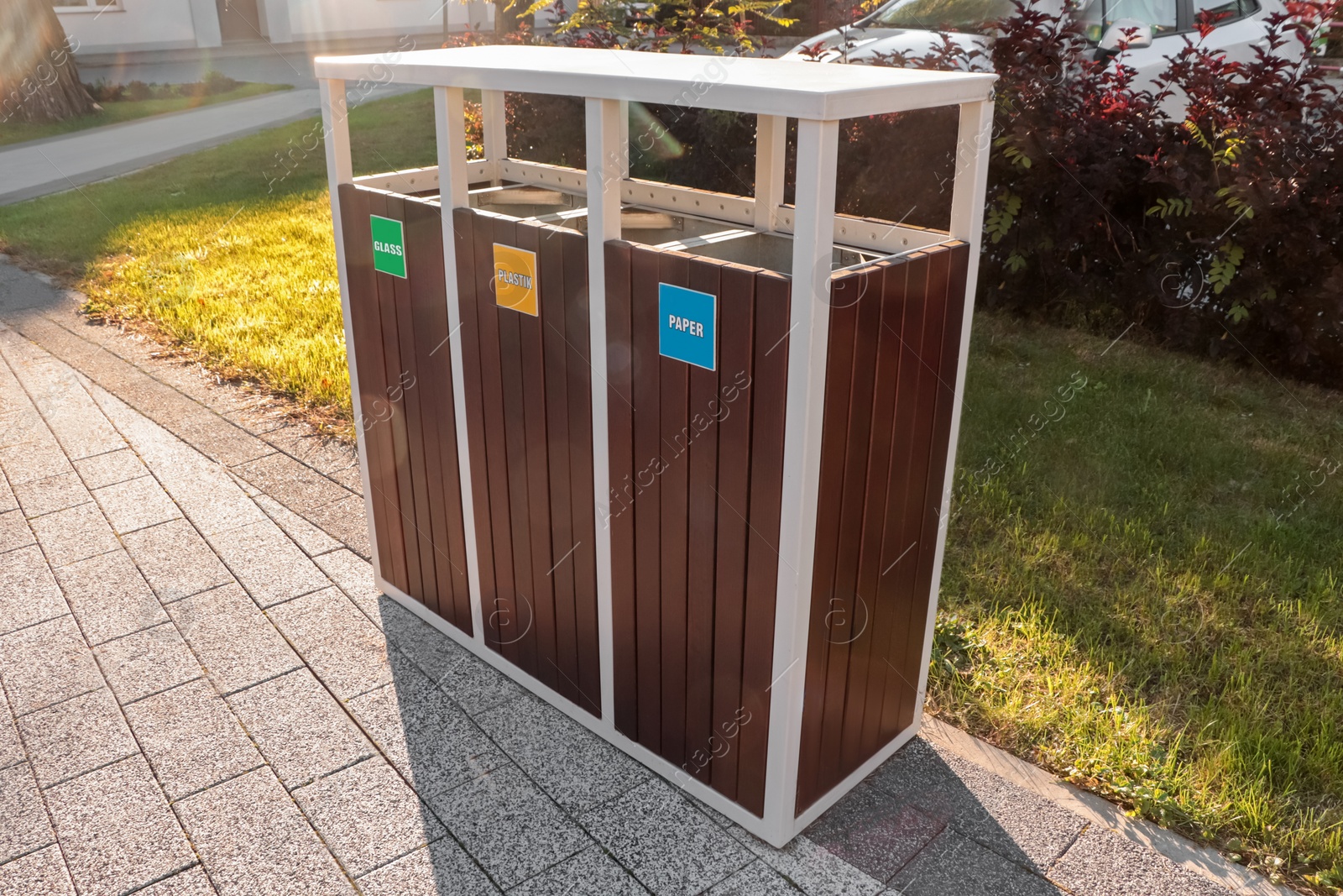 Photo of Different sorting bins for waste recycling on sunny day outdoors