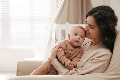 Happy young mother with her cute baby at home