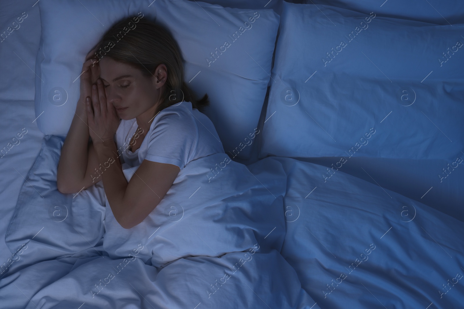 Photo of Woman sleeping in bed at night, above view. Space for text