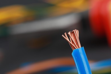 Photo of New colorful electrical wire on blurred background, closeup. Space for text