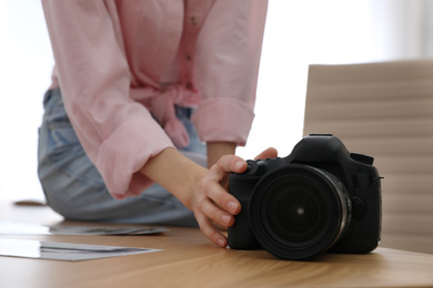 Photo of Professional photographer with camera working in office, closeup