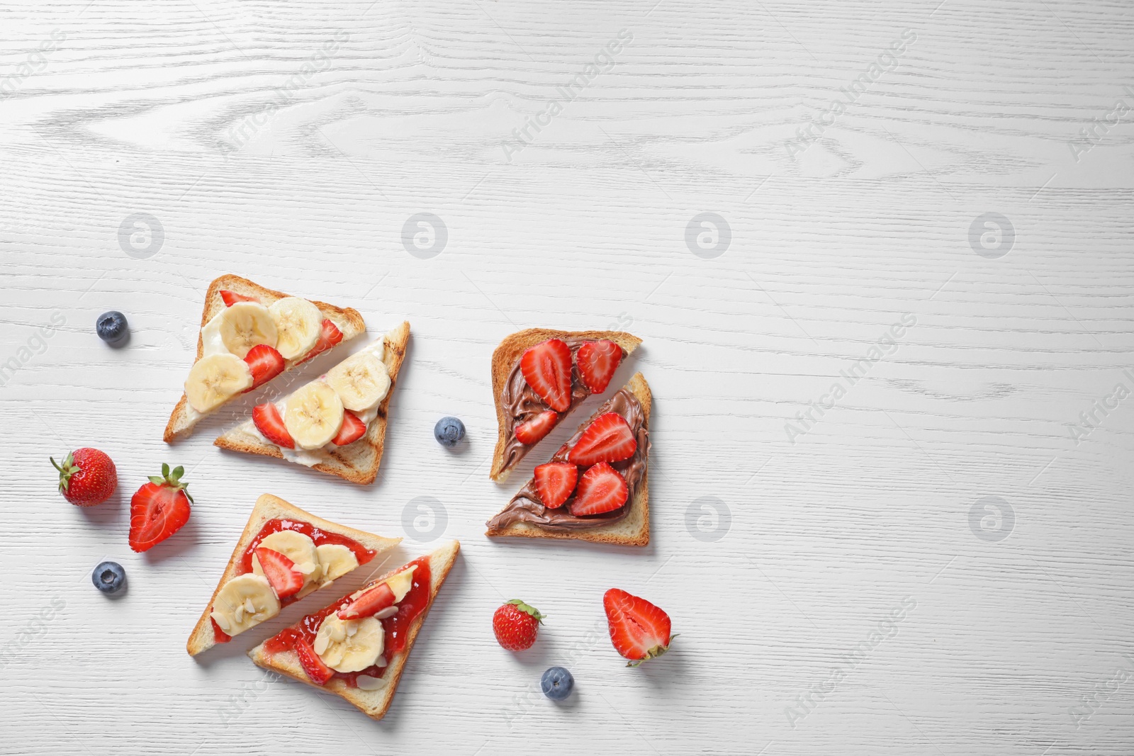 Photo of Tasty toast bread with banana and strawberry on light background