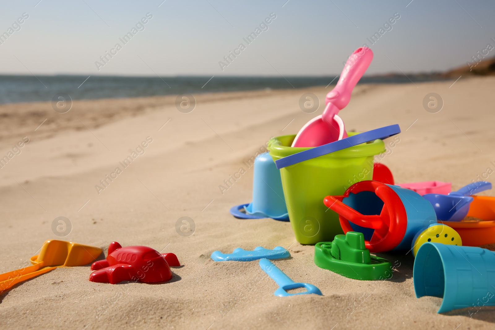 Photo of Set of plastic beach toys on sand, space for text. Outdoor play