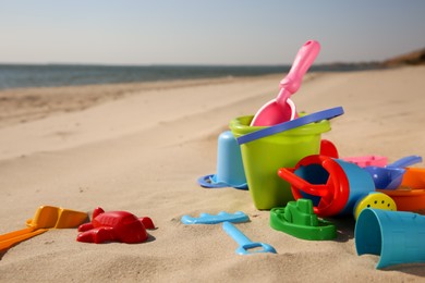 Set of plastic beach toys on sand, space for text. Outdoor play