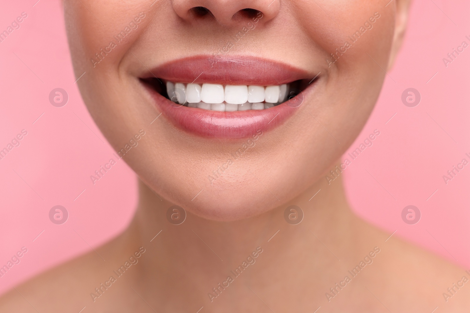 Photo of Woman with beautiful lips smiling on pink background, closeup