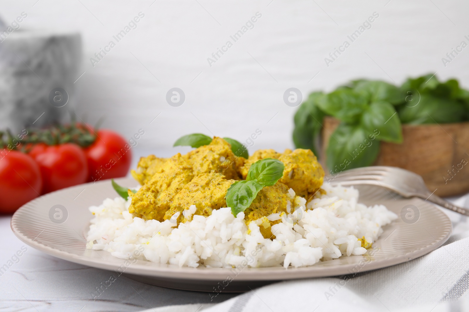 Photo of Delicious rice and chicken with curry sauce on white textured table, closeup