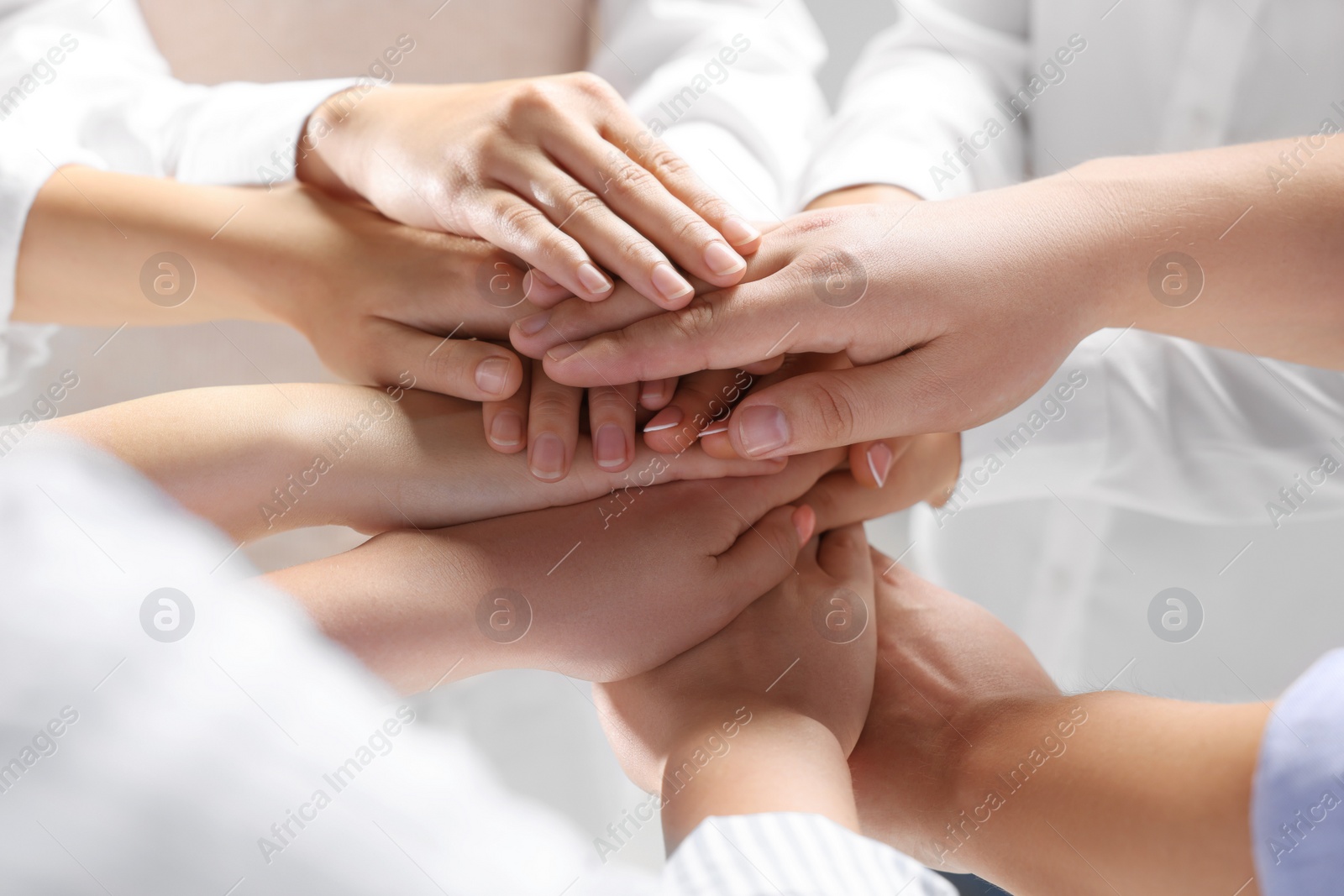 Photo of Group of people holding hands together indoors, closeup. Unity concept