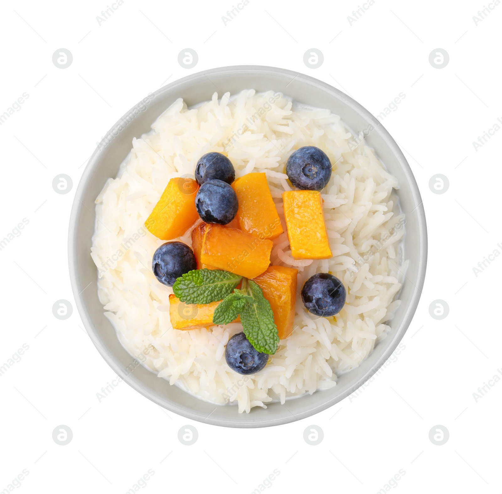 Photo of Bowl of delicious rice porridge with blueberries and pumpkin isolated on white, top view