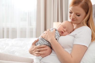 Photo of Mother with her sleeping baby in bedroom